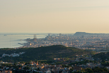 Panoramic view of the entire city of Barcelona and its surroundings. During sunset one day in late summer. We can see the Mediterranean sea completely flat.