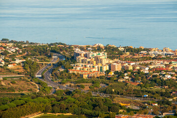 Fototapeta na wymiar Panoramic view of the Maresme coast, north coast of the city of Barcelona. During sunset one day in late summer. We can see the Mediterranean sea completely flat.