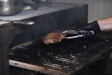 A chef in a very nice pub smokes pork ribs in a large oven