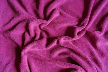 purple soft textile background with shadows and creases. top view. Copy space	
