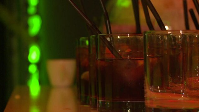 The bartender puts a straw in the punch