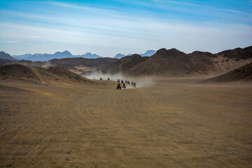 Fototapeta na wymiar tourists ride ATVs in the desert