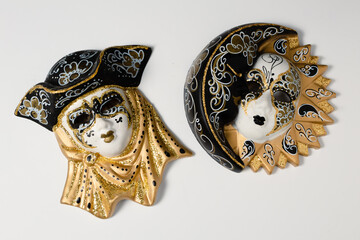 Venetian masks of white and black ceramic ornament with golden or gold highlights. White background.