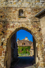 Fototapeta na wymiar Entering through the remains of the medieval fortifications the small village of Herisson in Auvergne, France
