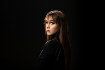 Young woman looking at camera isolated on black background