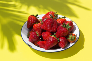 Fresh red strawberries on a yellow in sunny day