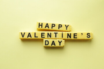 Happy Valentine's Day. An inscription made from yellow cubes. Creative concept.
