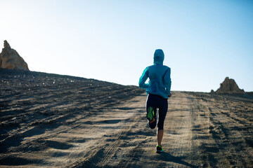 Fitness woman trail runner cross country running  on sand desert