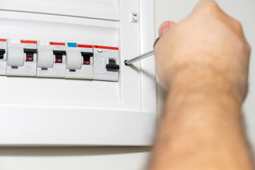 Electrician installing panel with electric meter in apartment of customer