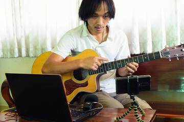 The man live traing the guitar practice streaming by smartphone