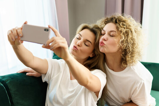 Two young girls taking selfie together at home