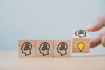 Hand flipping wooden cube block which print screen face with questions mark to lightbulb, creative...