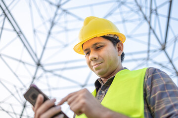 Electrical engineers asian using smartphone inspect the high voltage pole