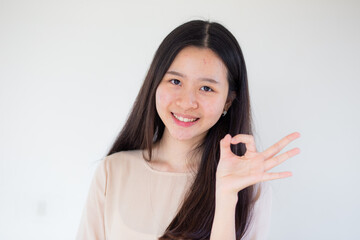 Happy young pretty woman standing over white background showing okay gesture.