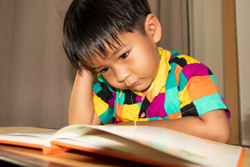 A boy sitting reading a book