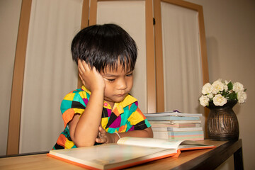 A boy sitting reading a book