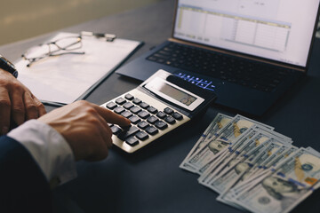Businessman using calculator and laptop for calculate bills Finances, savings and economy concept....