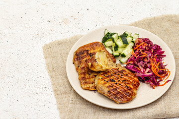 Healthy Paleo food with grilled meat, fresh cucumber, fermented cabbage and carrot