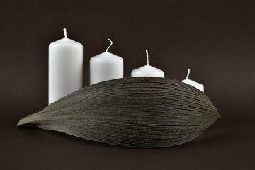 Grube, białe świeczki z ozdobami stołu na ciemnym tle. © Krzysztof Głowacki