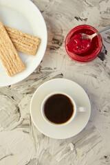 Crispbread with jam for Breakfast on a gray background. A jar of Fresh Honey with foam is next to a Cup of coffee. A minimum of calories. proper nutrition