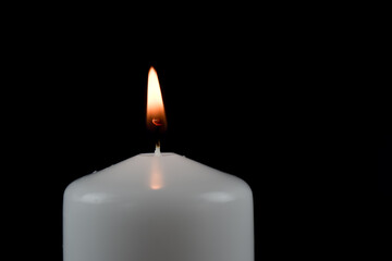 Białe, grube świeczki na ciemnym tle.