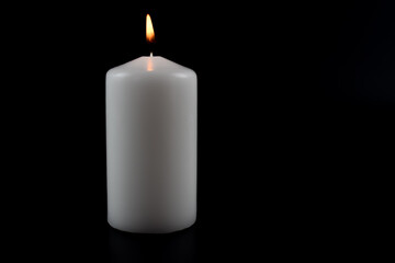 Fototapeta na wymiar Białe, grube świeczki na ciemnym tle.