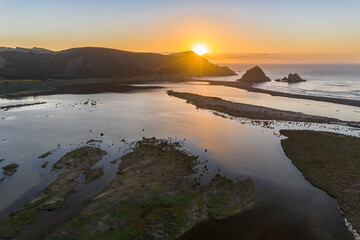 Amazing aerial view of a dreamlike beach in the central Chilean coast. Striking view of the waves coming from the sea and the wild coastline. A tranquil scenery in Topocalma beach during sunset time