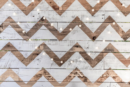White and natural wooden chevron-patterned background made from reclaimed wood with party lights