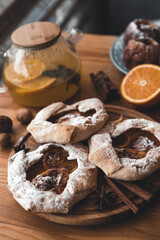 Fresh cookies with fruit orange jelly and mint on plate over rustic wooden background