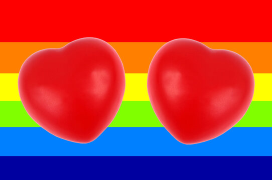 Deux coeurs en gros plan sur fond du drapeau arc-en-ciel symbole de la communauté homosexuelle