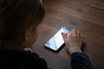 Young girl send message on  smartphone. Mobil phone,  technology and social ntework in everyday life concept. Shoulder view.