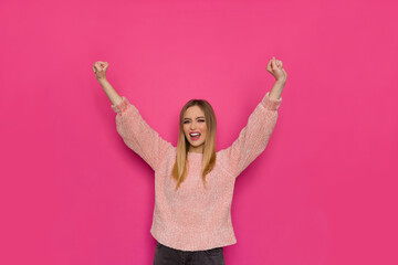 Happy Young Woman Is Holding Arms Raised And Shouting