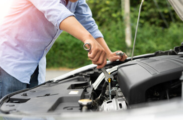 Hand of a car mechanic with a wrench Winding and checking engine readiness And engine oil level, engineer concept and car repair