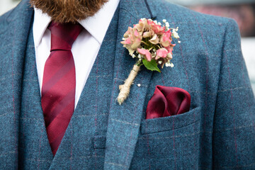 Close up of groom wearing tweed suit and boutonniere - obrazy, fototapety, plakaty