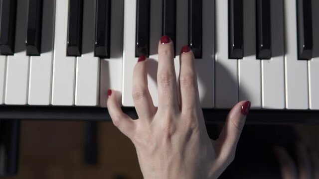 Close-up of the hands of a woman who is professional pianist playing the piano.