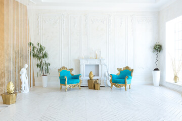 Luxury light interior of living room with gold wall and chic expensive furniture in white and gold colors