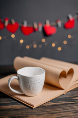 Heart made from book sheets with a cup in lights, love and valentine concept on a wooden table