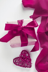 Gift box with craft paper and red ribbon on a white background