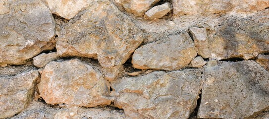Natural old beige stone wall textured banner. Close up. Copy space.	