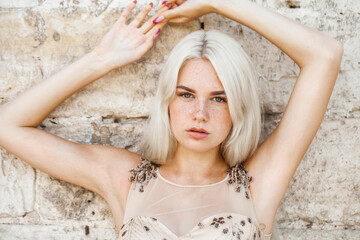 Young beautiful blonde girl in beige dress