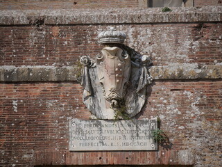 Closeup of the Lorraine coat of arms above the entrance door of the facade of San Rocco Fortress in Marina di Grosseto