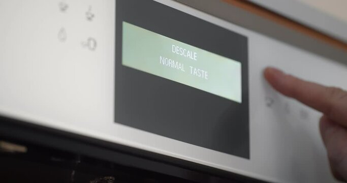 Close up of hand setting program on automatic coffee machine panel