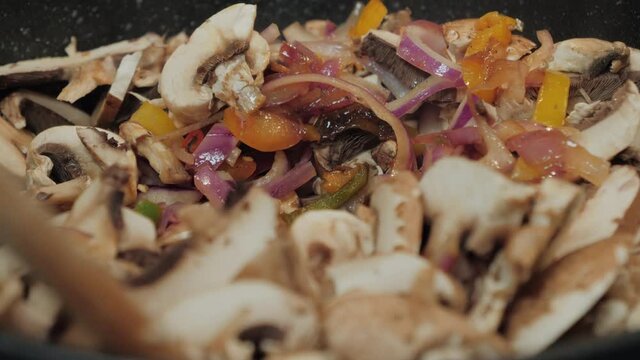 Motion controlled slow motion shot of mushrooms in a cooking pan