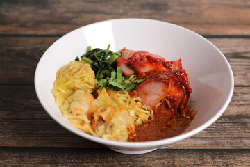 Shrimp dumpling with roasted pork with local thai tom yum spicy sauce on wood background