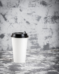 Working on the go. Coffee cup on grey stone table. Copy space