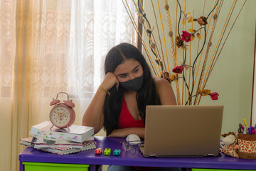 bored young woman with mask in from of laptop