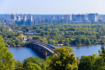 Obraz premium Aerial view of Metro bridge with subway train passing and the Dnieper river in Kiev, Ukraine. Kyiv cityscape