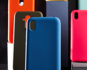 colorful cases for modern smartphones stand on stands on the table one object in focus blurred background