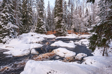 The mountain river Tokhmajoki near Ahvenkoski waterfall at sunny winter weather. Ruskeala, Karelia.