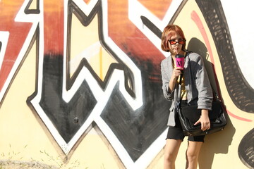 Girl standing by a graffiti wall
